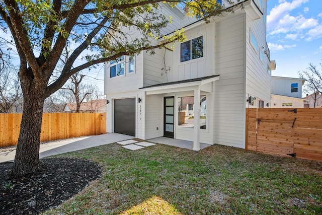 back of property featuring board and batten siding, a fenced backyard, and an attached garage