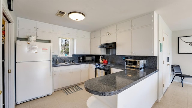 kitchen with dark countertops, a peninsula, under cabinet range hood, black appliances, and a sink