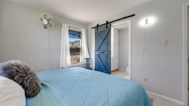 bedroom with a barn door and baseboards