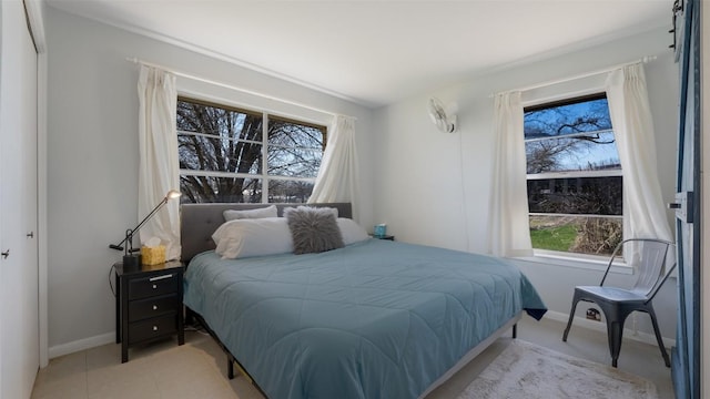 bedroom with baseboards and light tile patterned floors