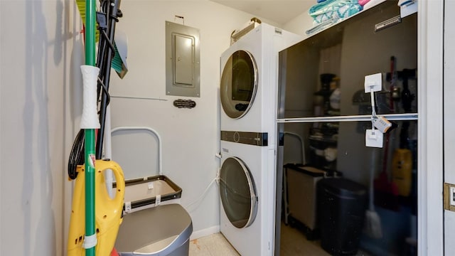 laundry room with electric panel and stacked washer / drying machine