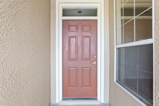 property entrance with stucco siding