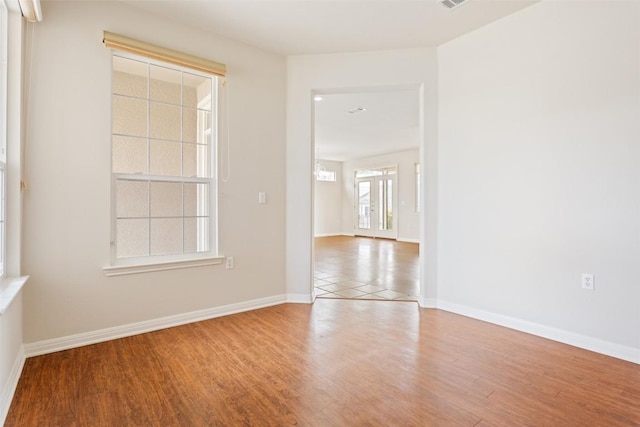 spare room with visible vents, wood finished floors, and baseboards