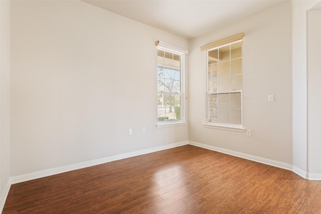 empty room featuring baseboards and wood finished floors