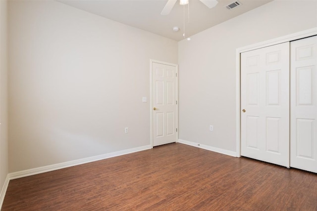 unfurnished bedroom featuring visible vents, dark wood-style floors, a closet, baseboards, and ceiling fan