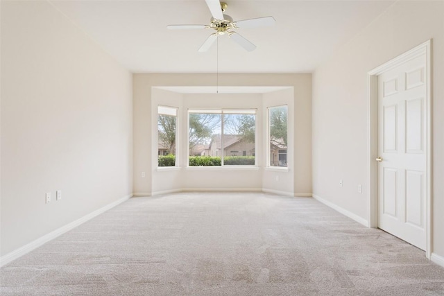 empty room with a ceiling fan, baseboards, and carpet floors