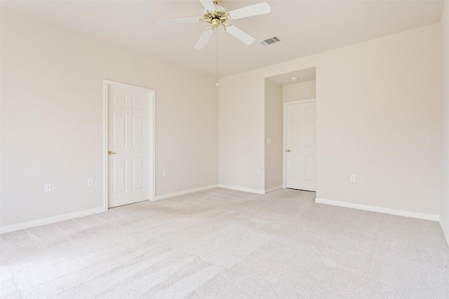 unfurnished room featuring visible vents, baseboards, light colored carpet, and ceiling fan