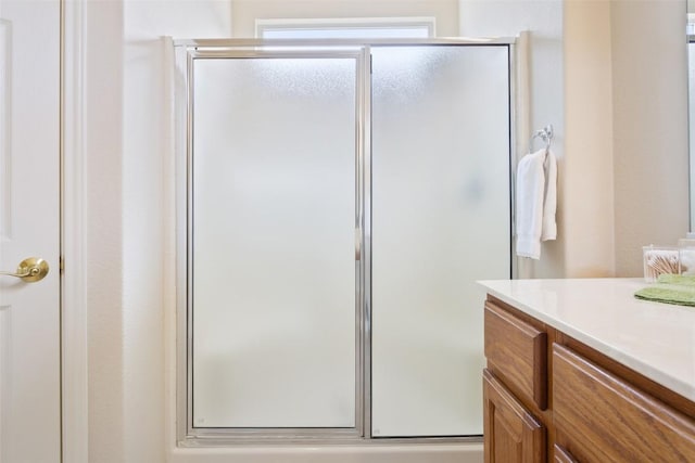 full bath with a shower stall and vanity