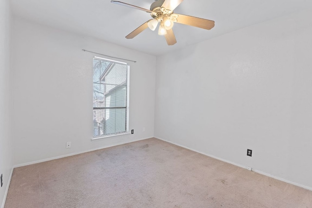 spare room with ceiling fan, carpet, and baseboards