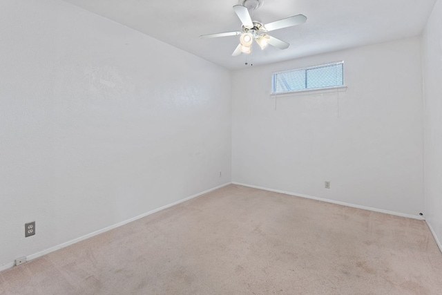 spare room with carpet, baseboards, and a ceiling fan