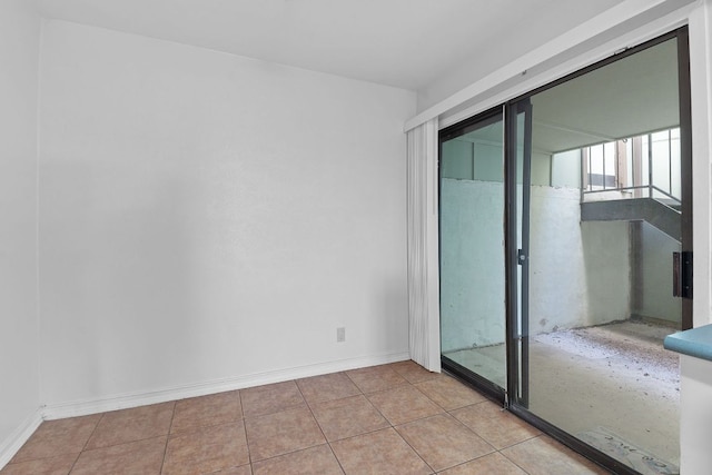 spare room featuring baseboards and tile patterned floors