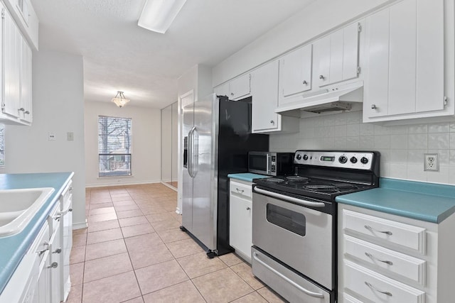 kitchen with light tile patterned floors, under cabinet range hood, stainless steel appliances, white cabinetry, and tasteful backsplash