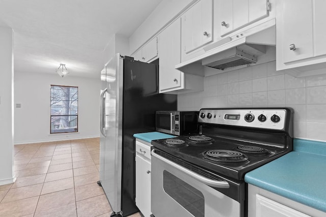 kitchen featuring light tile patterned floors, appliances with stainless steel finishes, white cabinets, and decorative backsplash