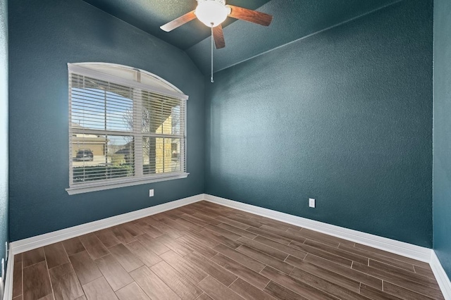 spare room featuring wood finish floors, vaulted ceiling, and baseboards