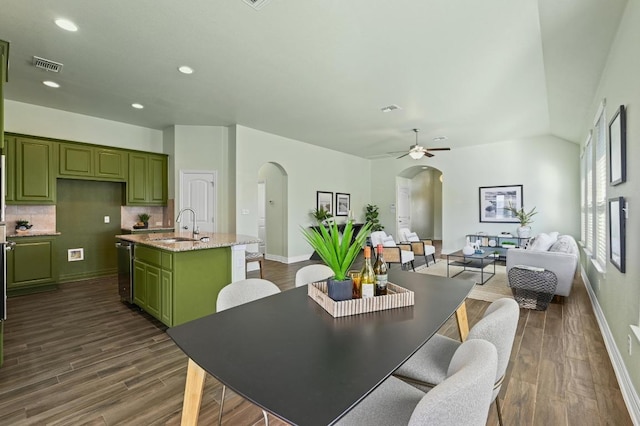 dining space featuring arched walkways, dark wood-style flooring, recessed lighting, visible vents, and baseboards