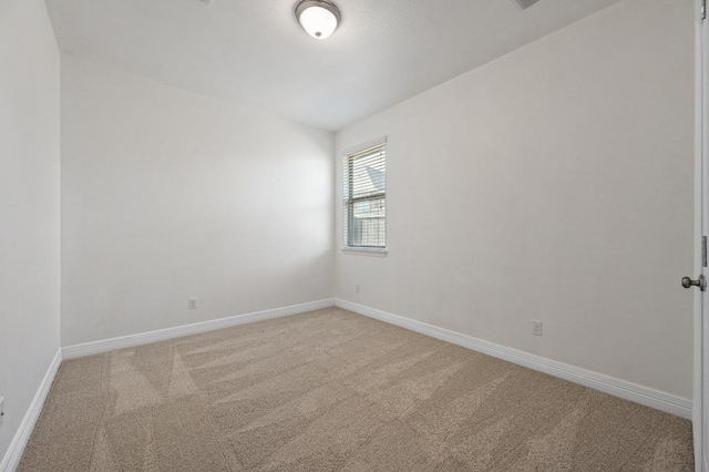 unfurnished room with baseboards and light colored carpet