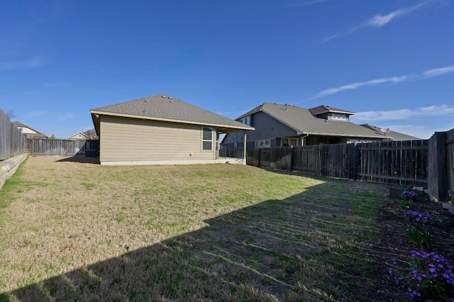 back of house with a fenced backyard and a lawn