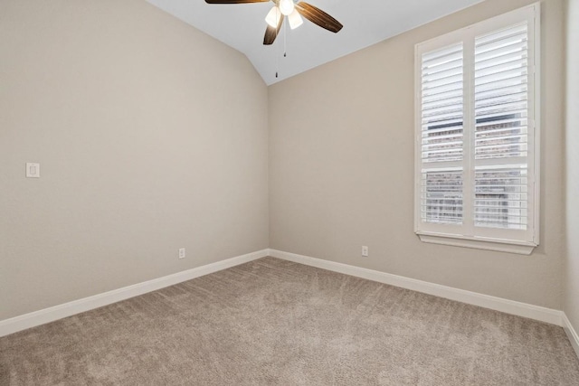 carpeted spare room with lofted ceiling, ceiling fan, and baseboards