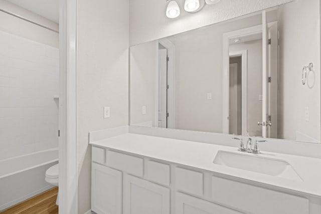 bathroom with shower / bath combination, vanity, toilet, and wood finished floors