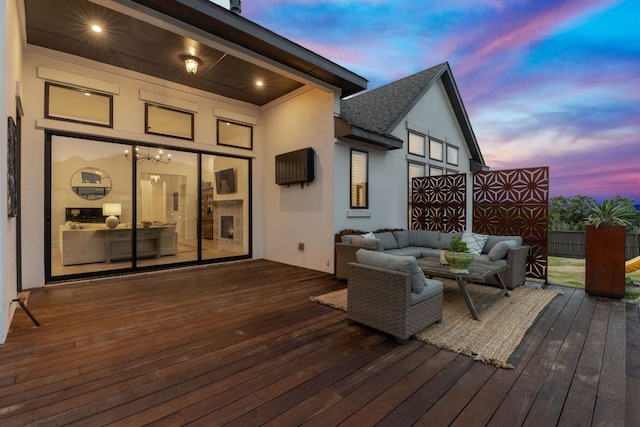 deck at dusk with outdoor lounge area and fence