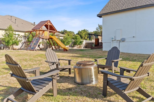 view of yard featuring an outdoor fire pit, a playground, and fence