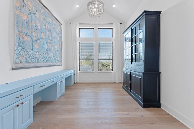 interior space featuring light wood finished floors, baseboards, vaulted ceiling, an inviting chandelier, and built in study area