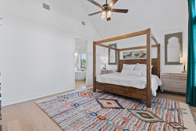 bedroom featuring visible vents, high vaulted ceiling, connected bathroom, and light wood finished floors