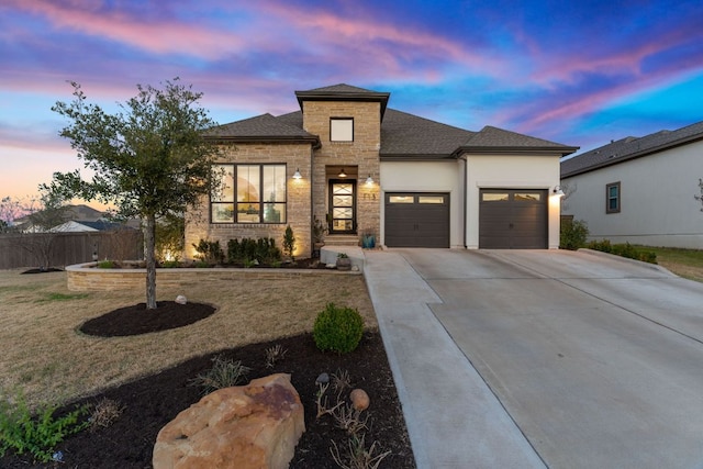 prairie-style home with concrete driveway, a garage, and roof with shingles