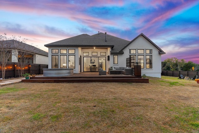 rear view of property featuring a wooden deck, a fenced backyard, a hot tub, outdoor lounge area, and a lawn