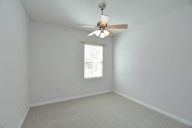 spare room featuring carpet, ceiling fan, and baseboards