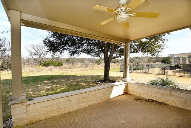 view of patio with ceiling fan and fence