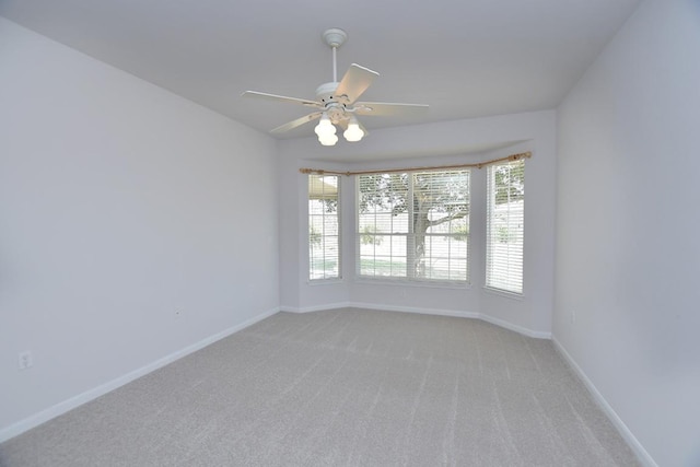 empty room with light carpet, baseboards, and a ceiling fan