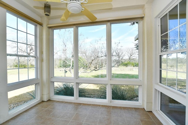 unfurnished sunroom with a ceiling fan