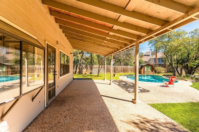 7701 Penelope Cir, Austin, TX 78759 - view of patio with a fenced in pool, an outbuilding, a fenced backyard, and a storage shed
