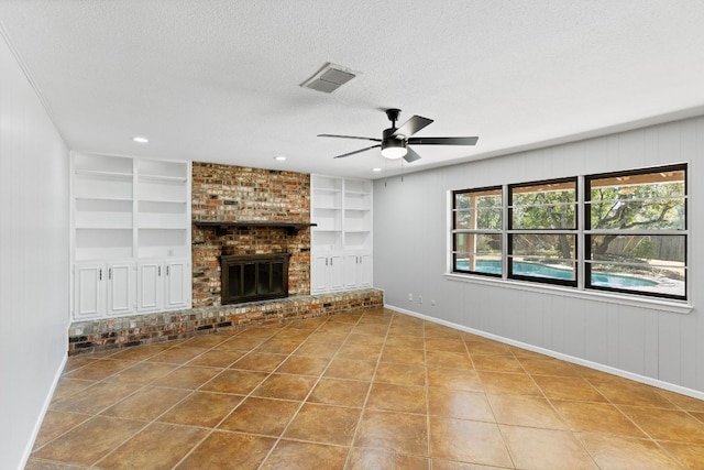 7701 Penelope Cir, Austin, TX 78759 - unfurnished living room with a textured ceiling, visible vents, built in features, a brick fireplace, and tile patterned floors