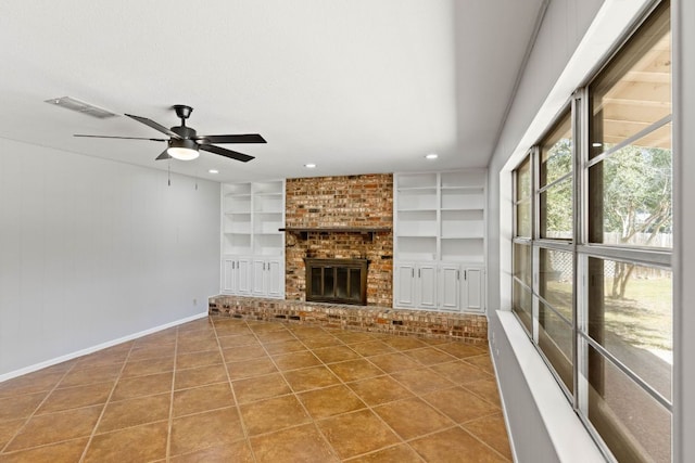7701 Penelope Cir, Austin, TX 78759 - unfurnished living room with built in shelves, visible vents, a brick fireplace, baseboards, and tile patterned floors