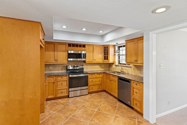 7701 Penelope Cir, Austin, TX 78759 - kitchen with stainless steel appliances, decorative backsplash, a sink, dark stone countertops, and baseboards