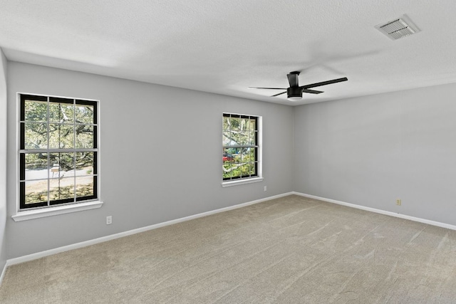 7701 Penelope Cir, Austin, TX 78759 - spare room featuring baseboards, visible vents, a ceiling fan, light colored carpet, and a textured ceiling