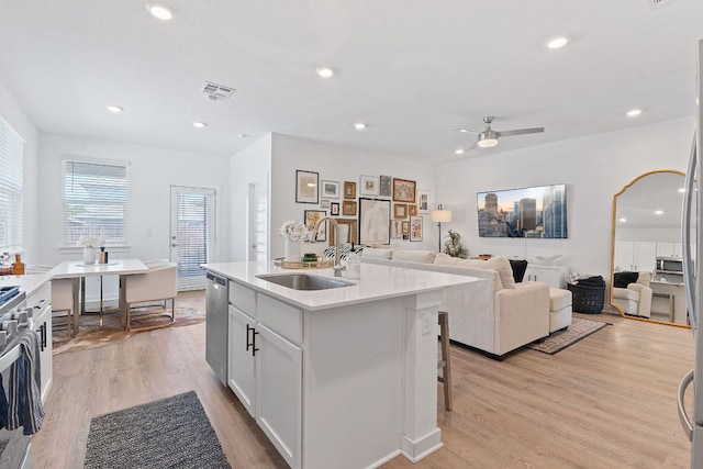 kitchen with visible vents, appliances with stainless steel finishes, open floor plan, light wood-type flooring, and a sink