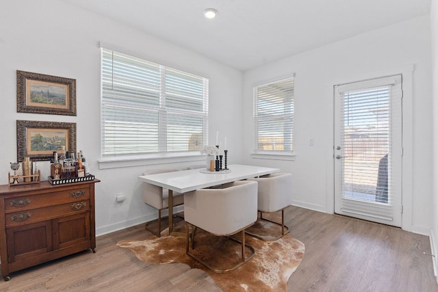 dining area with light wood-type flooring and baseboards