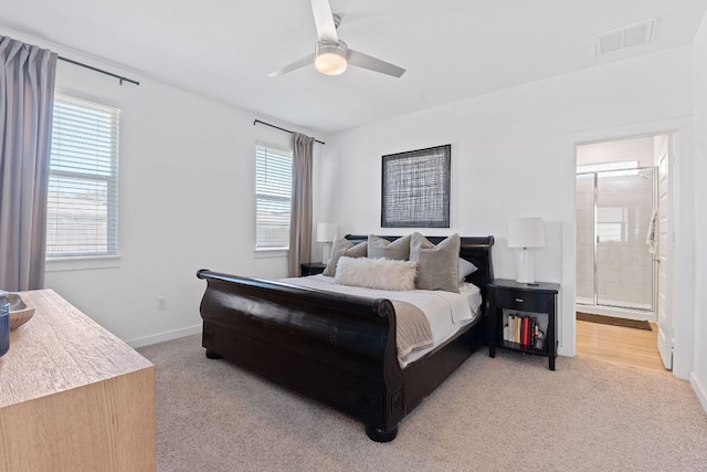 bedroom with connected bathroom, light colored carpet, a ceiling fan, baseboards, and visible vents