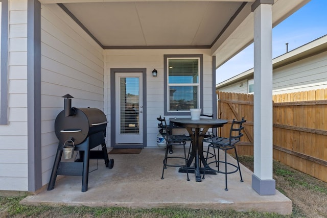 view of patio featuring outdoor dining area and fence