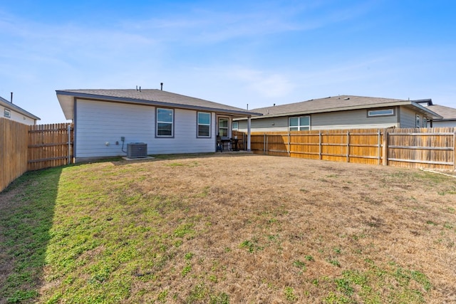 back of house featuring a yard, a fenced backyard, and cooling unit