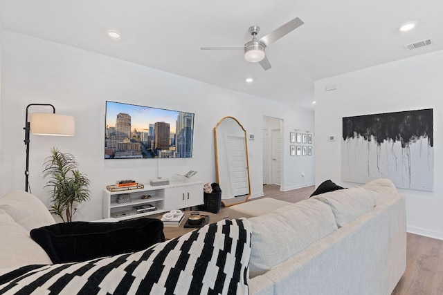 living area with recessed lighting, visible vents, light wood-style flooring, a ceiling fan, and baseboards