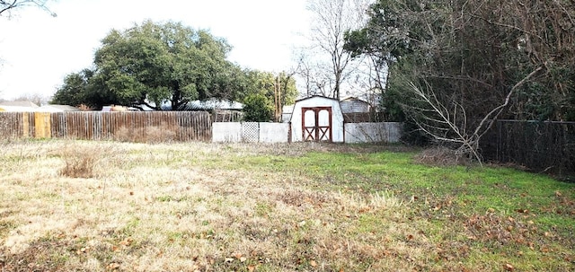 view of yard featuring a storage unit, fence, and an outbuilding