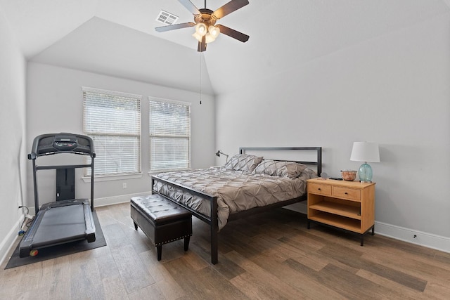 bedroom featuring lofted ceiling, wood finished floors, visible vents, and baseboards