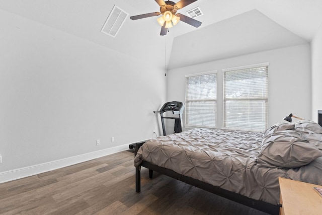 bedroom featuring lofted ceiling, visible vents, baseboards, and wood finished floors