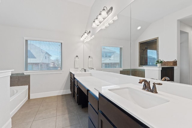 full bath with a garden tub, a sink, vaulted ceiling, tile patterned floors, and double vanity