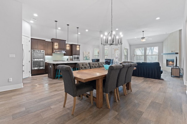 dining area featuring light wood-style floors, a fireplace, and recessed lighting