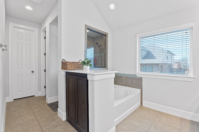 full bathroom featuring lofted ceiling, tile patterned flooring, baseboards, a bath, and walk in shower